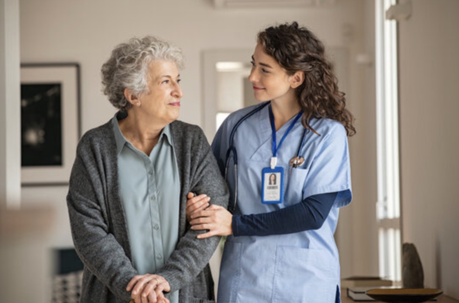 A nurse supports an older person at home.