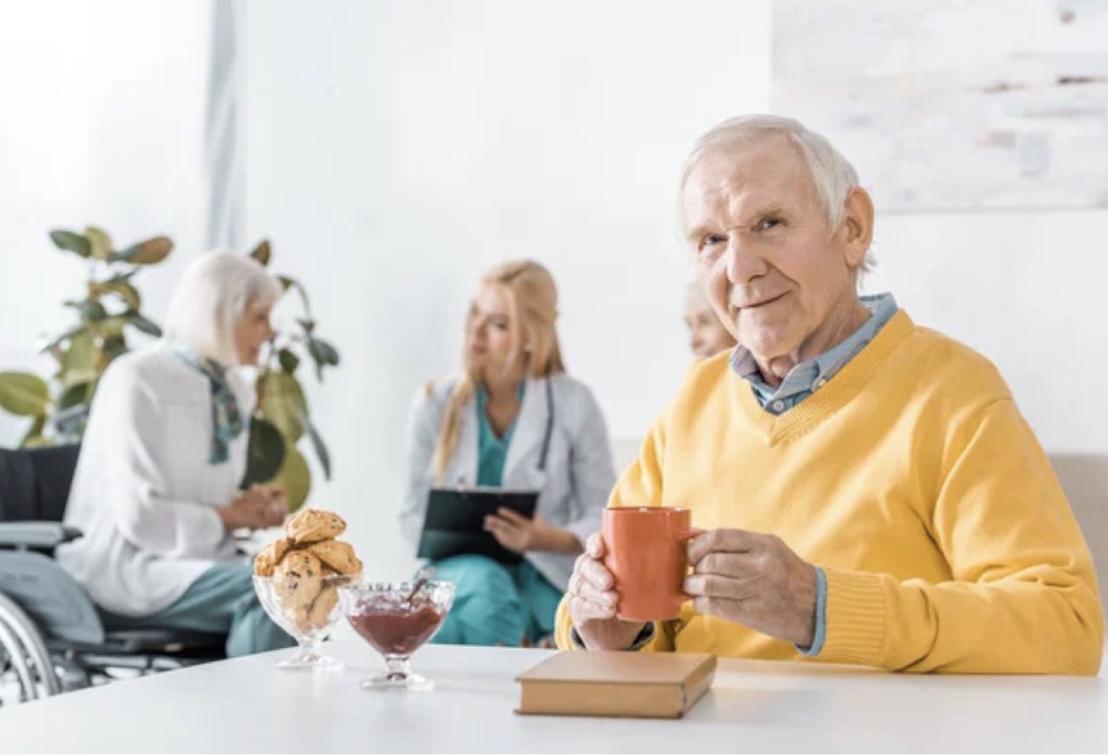 An older man holding a mug at home.